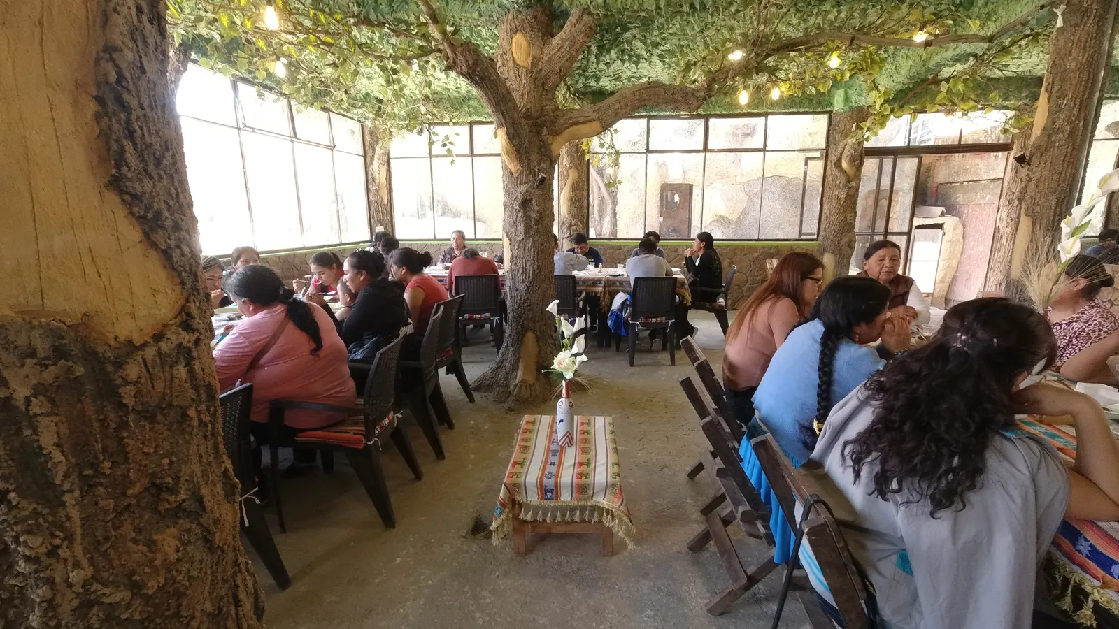 Comensales en el salón del restaurante decorado como un bosque con árboles