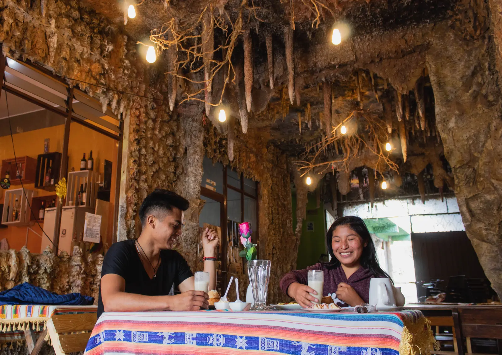Pareja cenando en el salón del restaurante decorado como una caverna con estalactitas