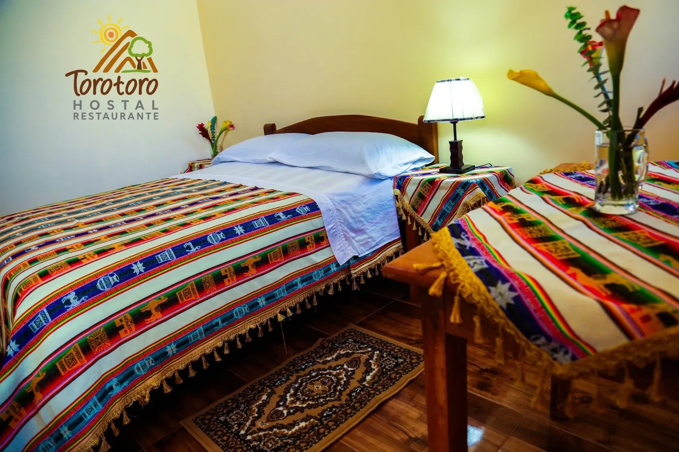 Habitación matrimonial con cama de dos plazas y aguayos de colores
